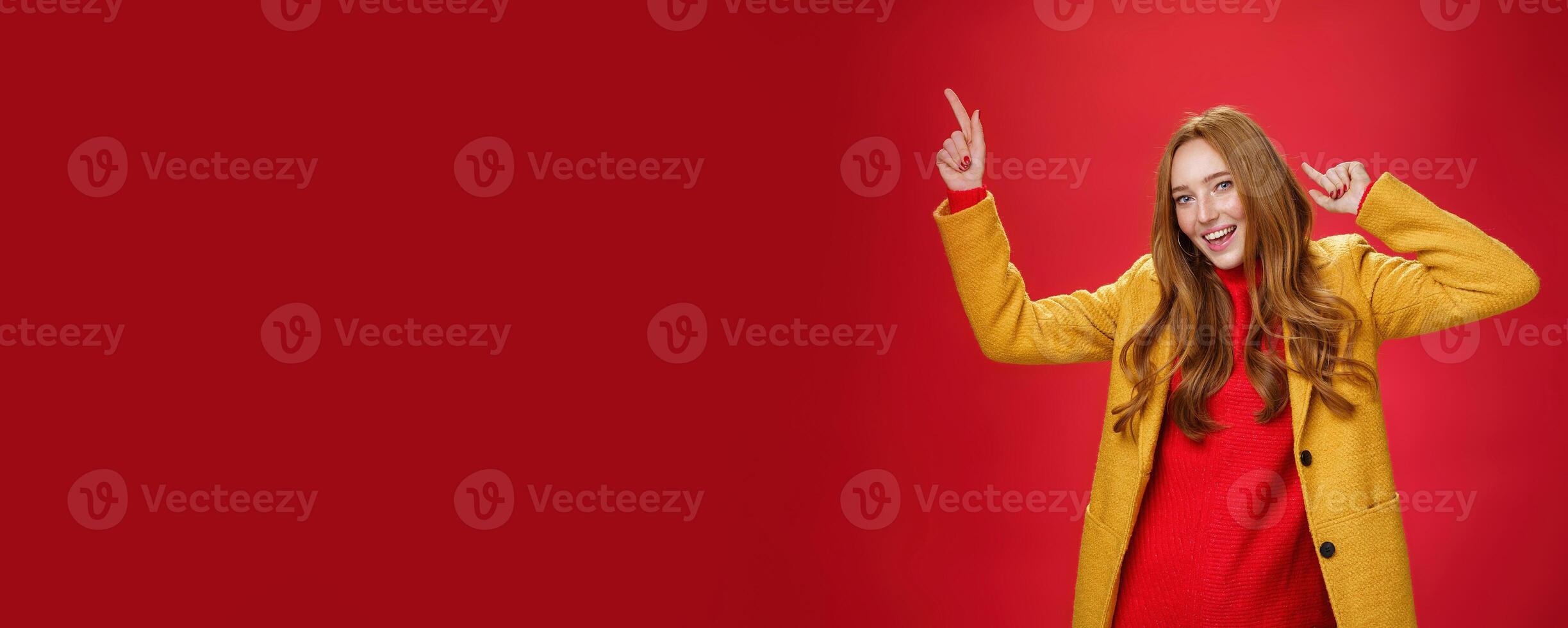 Hey dancing all night. Portrait of cheerful and excited ginger girl having fun as feeling happy and delighted of bright day moving to rhythm of music with disco moves and smiling broadly at camera photo