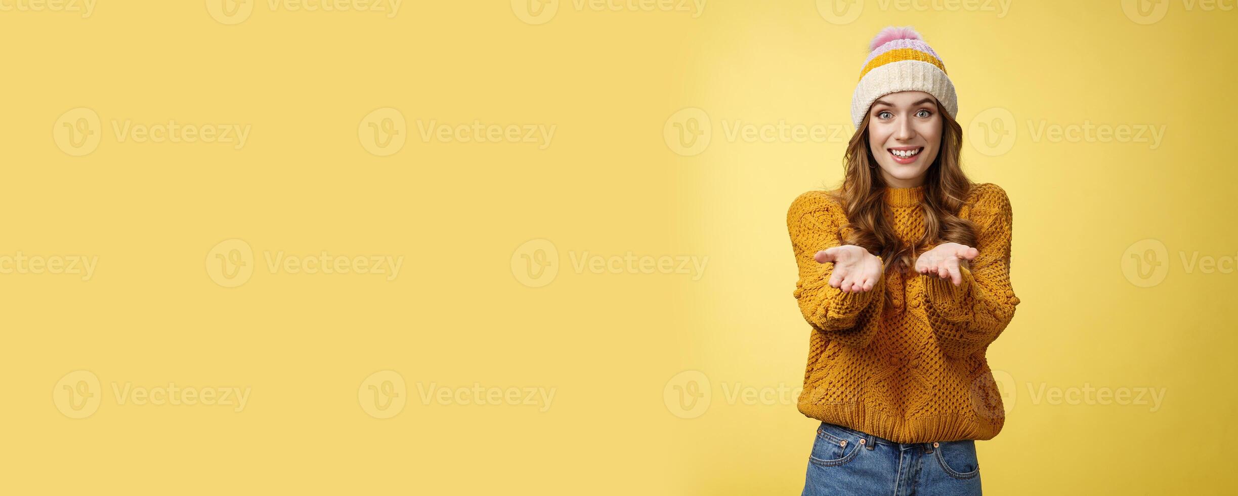 Girl suggesting take her heart smiling broadly friendly extending arms towards camera proposing help smiling delighted feeling upbeat wanna thank friend grateful appreciating effort, yellow wall photo
