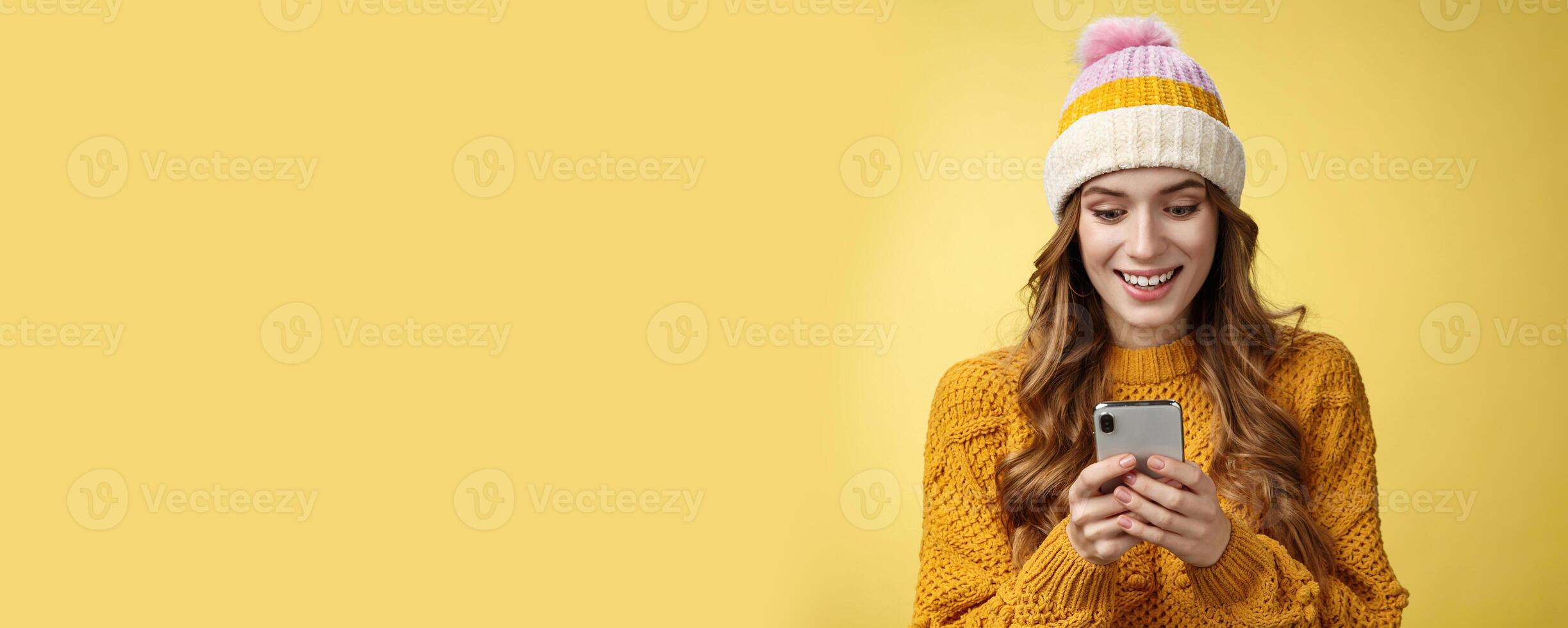 Amazed surprised cute girl receive good news reading exciting message hold smartphone widen eyes smiling mobile phone display, playing awesome cellphone game texting, send pics winters vacation photo