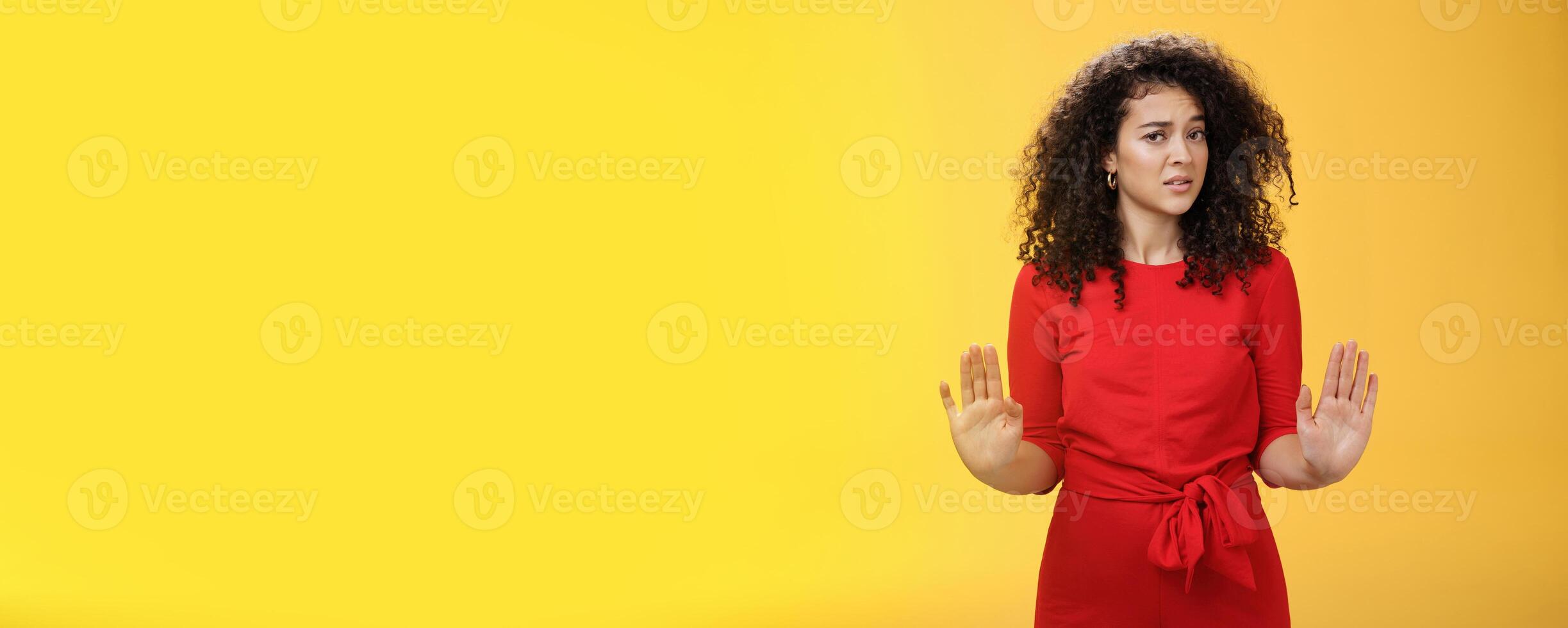 Girl unwiling got in troubles rejecting suspicious and doubtful offer pulling raised palms in no and refusal gesture turning head with grimace from aversion and disgust looking with contempt at camera photo