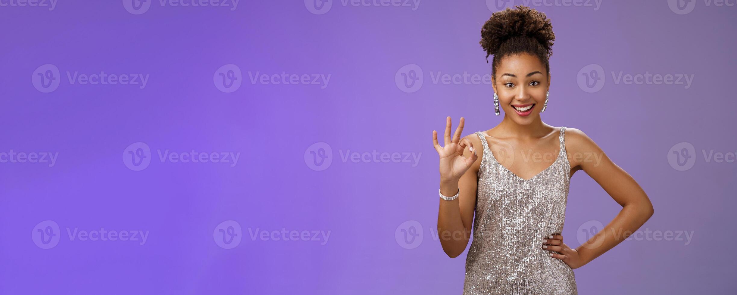 Friendly glad charming elegant african-american woman agree terms show okay ok satisfaction gesture delighted approve good idea standing blue background like plan smiling broadly photo