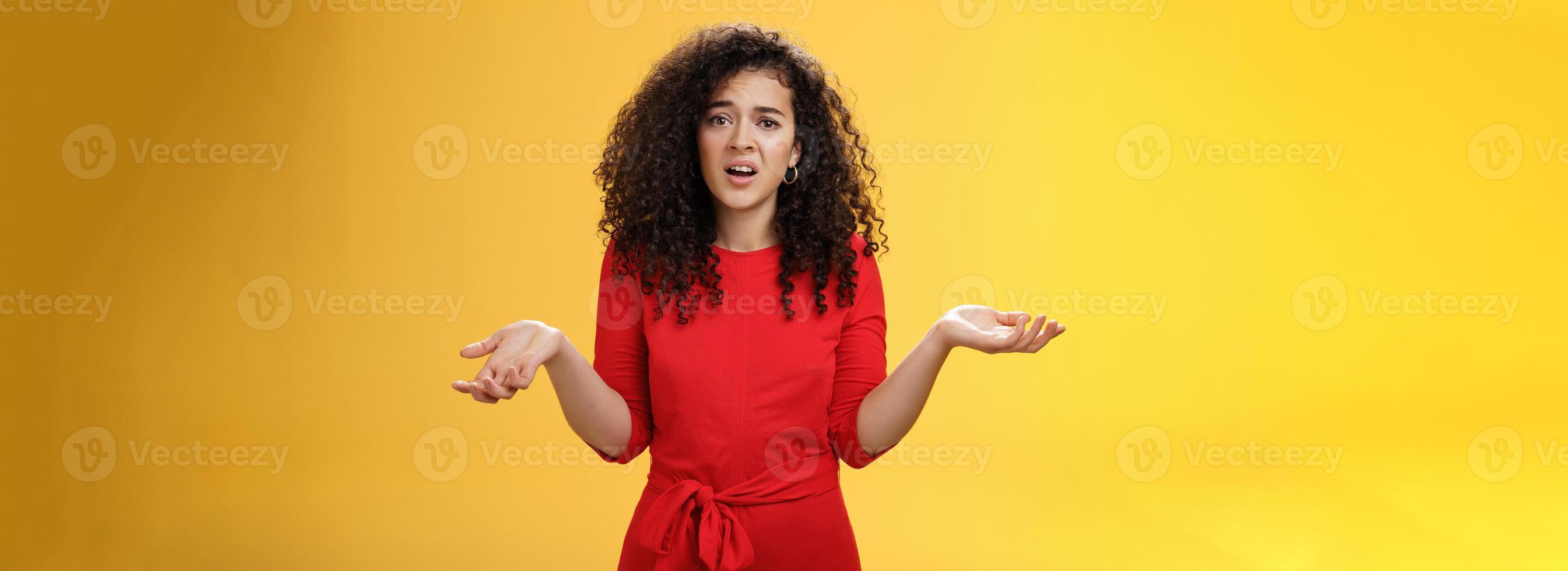 What your problem. Annoyed and confused pissed girlfriend with curly hair in elegant party dress shrugging with hands spread sideways and clueless grimace, waiting explanation during argument photo