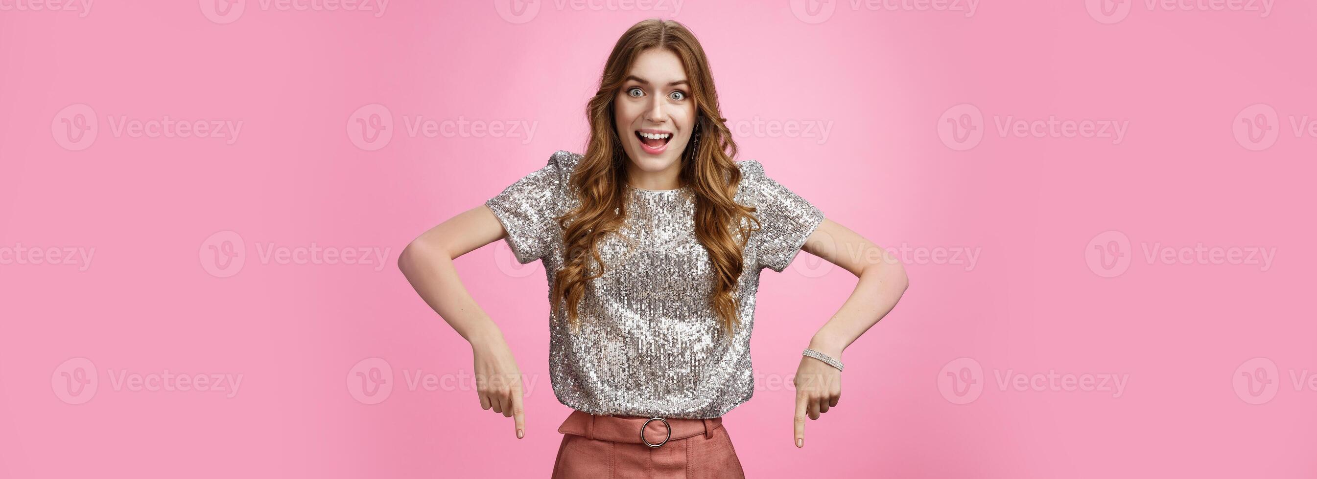 Studio shot impressed excited attractive young fashionable woman drop jaw thrilled pointing down index fingers amazing awesome promo advertisement, showing copy space astonished overwhelmed photo