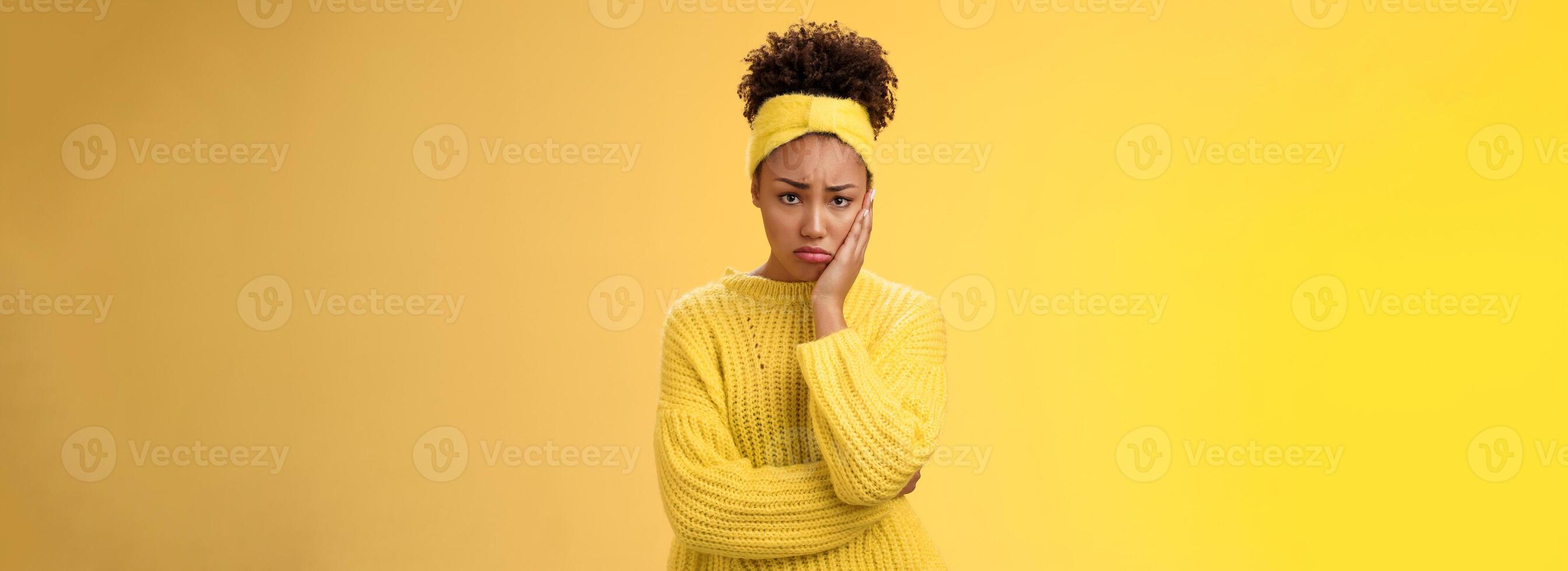 Upset cute gloomy young timid girl offended feel sadness regret touch cheek painful toothache make upset miserable pitty expression, troubled uncertain what do standing insecure yellow background photo