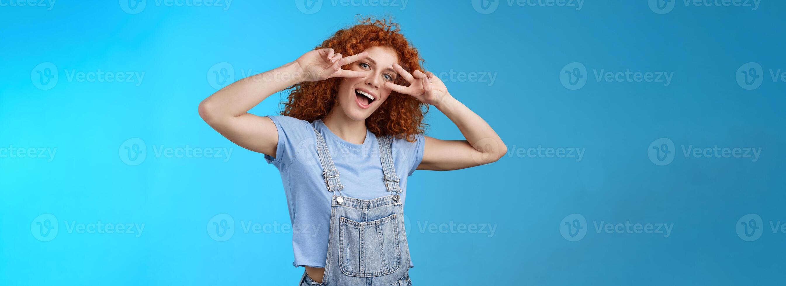 Say cheeze hello summer. Cheerful charming playful charismatic redhead cute girl curly hairstyle show tongue peace victory gesture eyes tilt head joyful mimicking funny attitude happy emotions photo