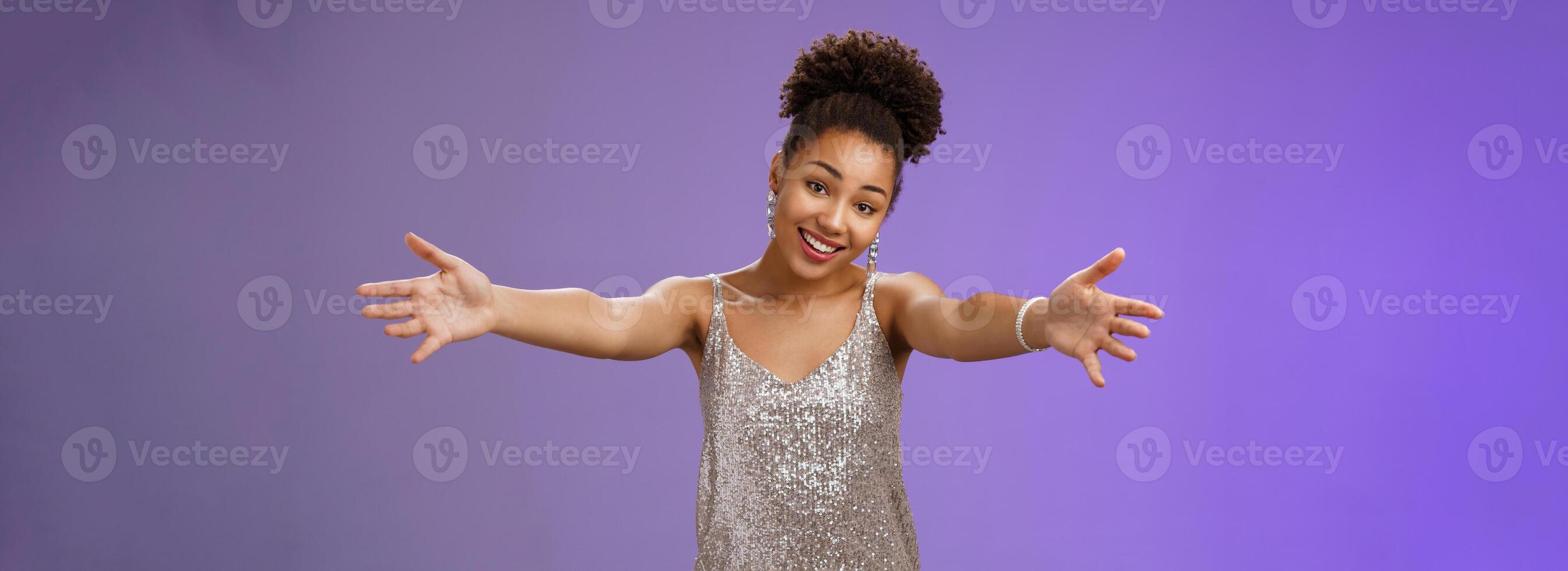 Lovely touched african-american female in evening slver dress extend arms hug give cuddle tilt head smiling friendly wanna ebrace friend gladly standing blue background heartwarming welcome photo