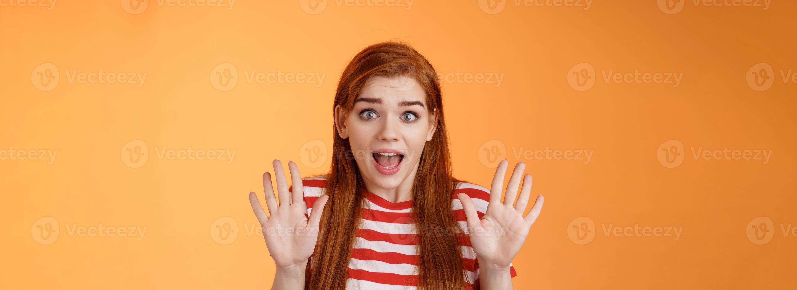 Shocked inssecure worried redhead woman plead not guilty, trying calm down angry customer, raise hands surrender innocent, open mouth, stare concerned camera, defend herself, explain situation photo