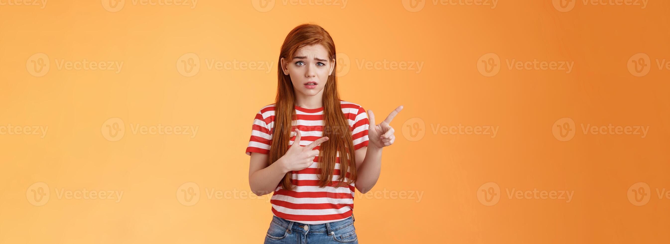 Insecure questioned frustrated cute redhead girl feel nervous unsure about suspicious offer frowning, grimacing doubtful and hesitant, pointing left look camera puzzled, asking question photo
