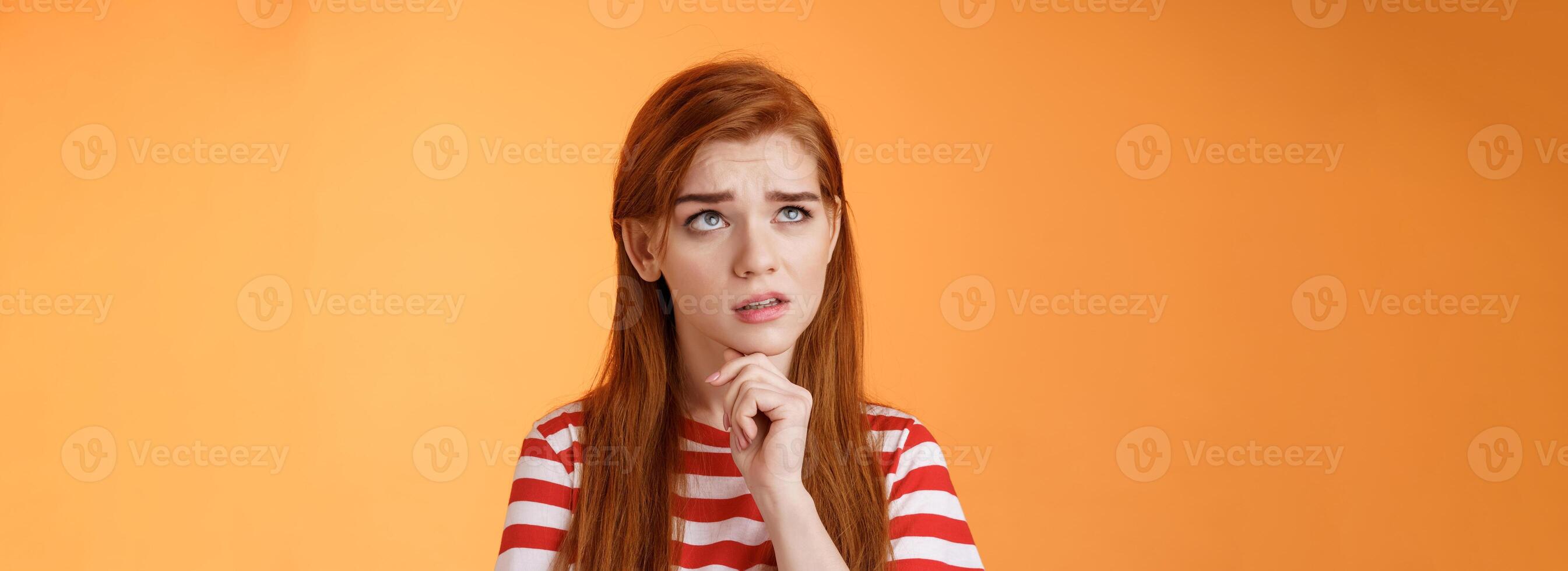Perplexed redhead woman trying make calculations mind, frowning focused, look up puzzled thoughtful, touch chin, thinking, pondering important decision, make choice, solve problem photo