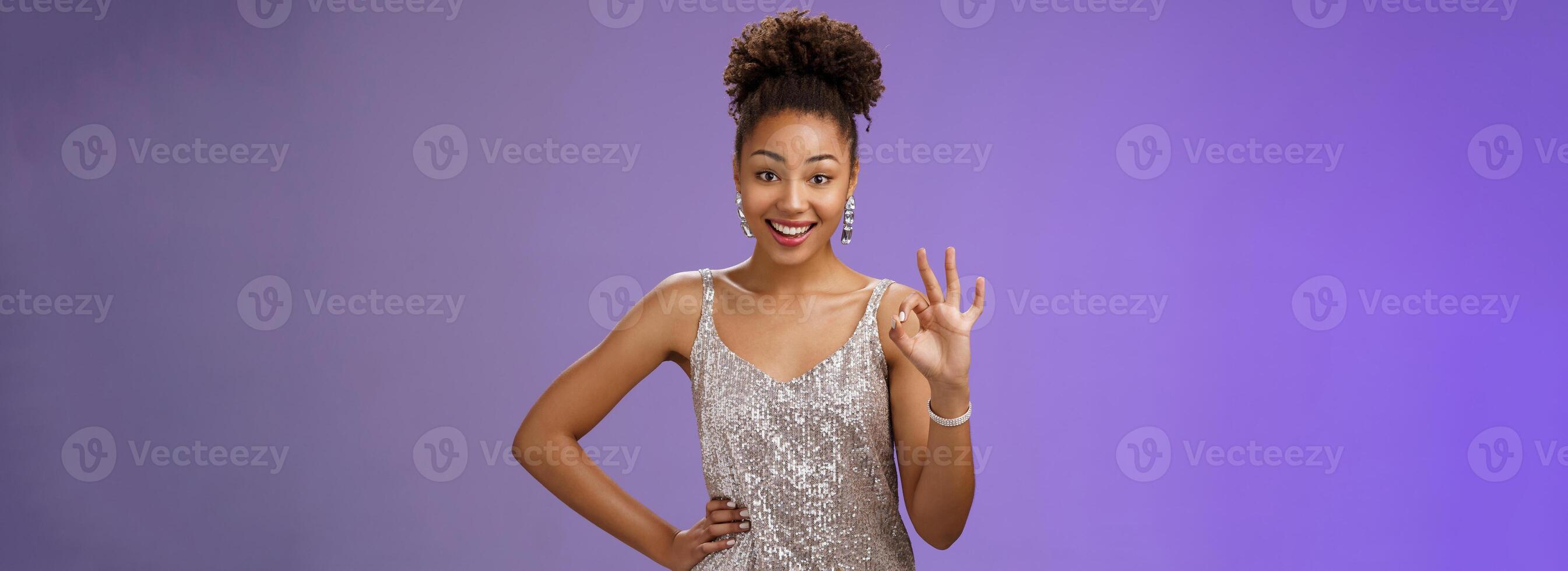 Friendly glad charming elegant african-american woman agree terms show okay ok satisfaction gesture delighted approve good idea standing blue background like plan smiling broadly photo