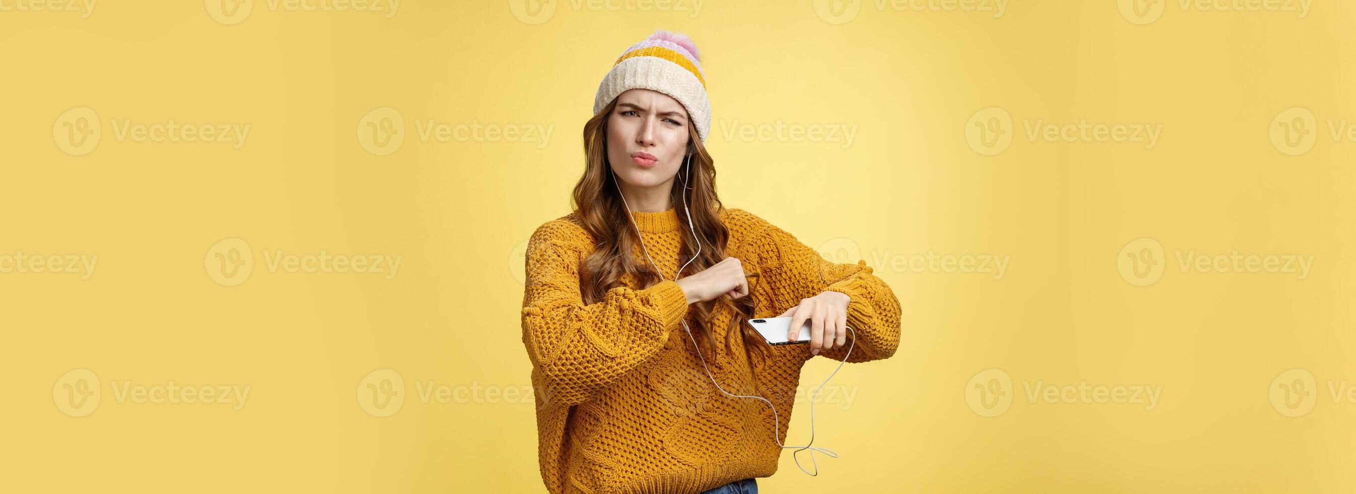 Shake your body. Portrait cool amused good-looking stylish girlfriend listen music via wired earphones dancing moving hands rhythm cool song holding smartphone folding lips frowning satisfied photo