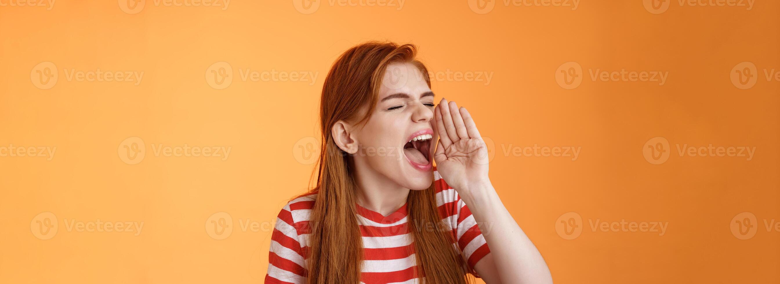 Hey where are you. Cute carefree redhead funny girl hold hand near opened mouth turn left close eyes, yelling out loud, searching someone, calling friend come upstairs, look for person distance photo