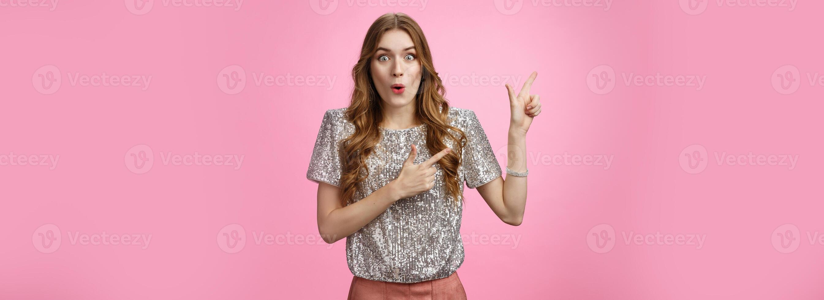 Attractive young girlfriend retelling incredible gossip spread party folding lips wow sound pointing upper left corner amused thrilled standing impressed pink background, lose speech awesome promo photo