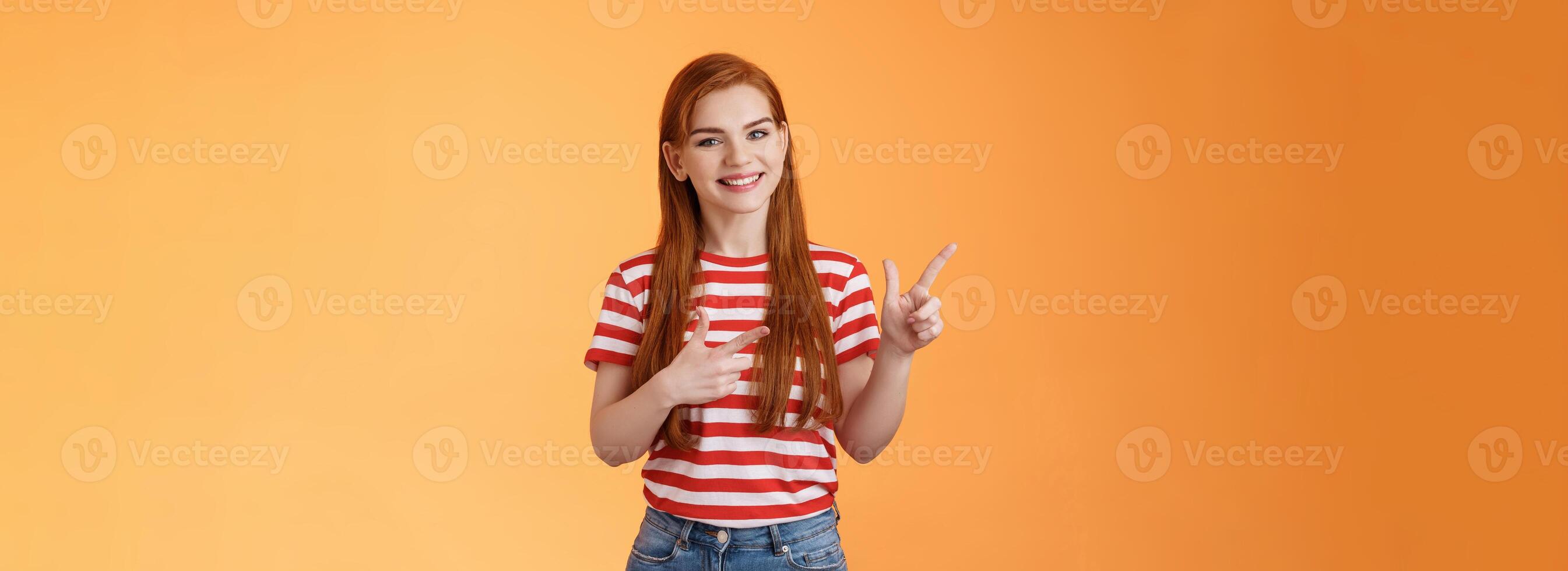 Cheerful pleasant female professional assistant showing customers office, pointing left smiling cheerful, gladly help out pick product, introduce new promos copy space, stand orange background photo
