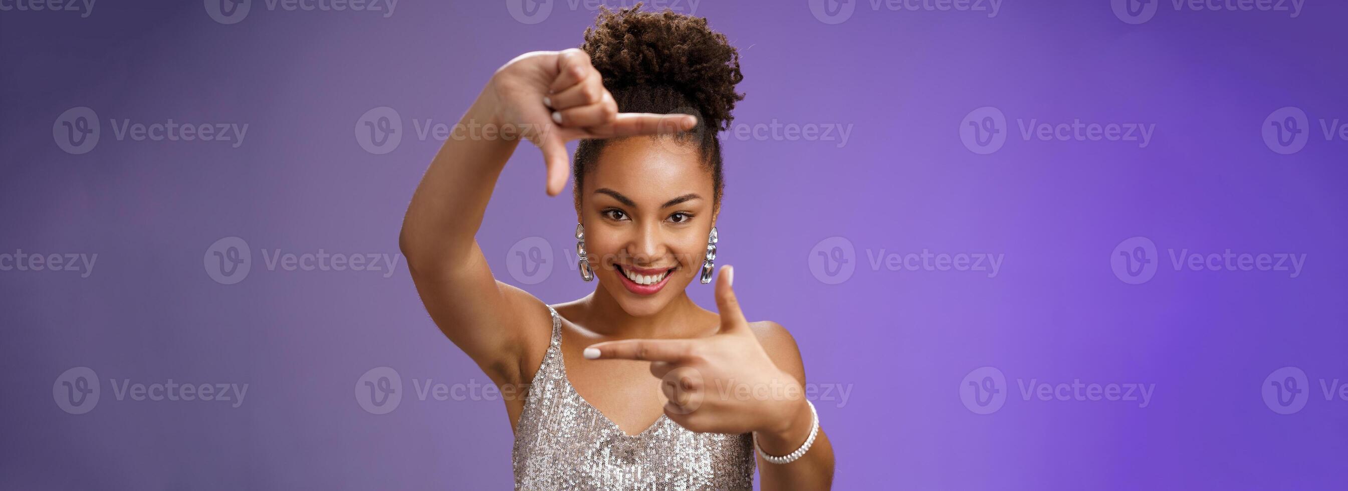 Elegant attractive happy creative african american girl in silver shiny dress make finger frames smiling through it search inspiration looking confident found perfect angle design idea, spot goal photo