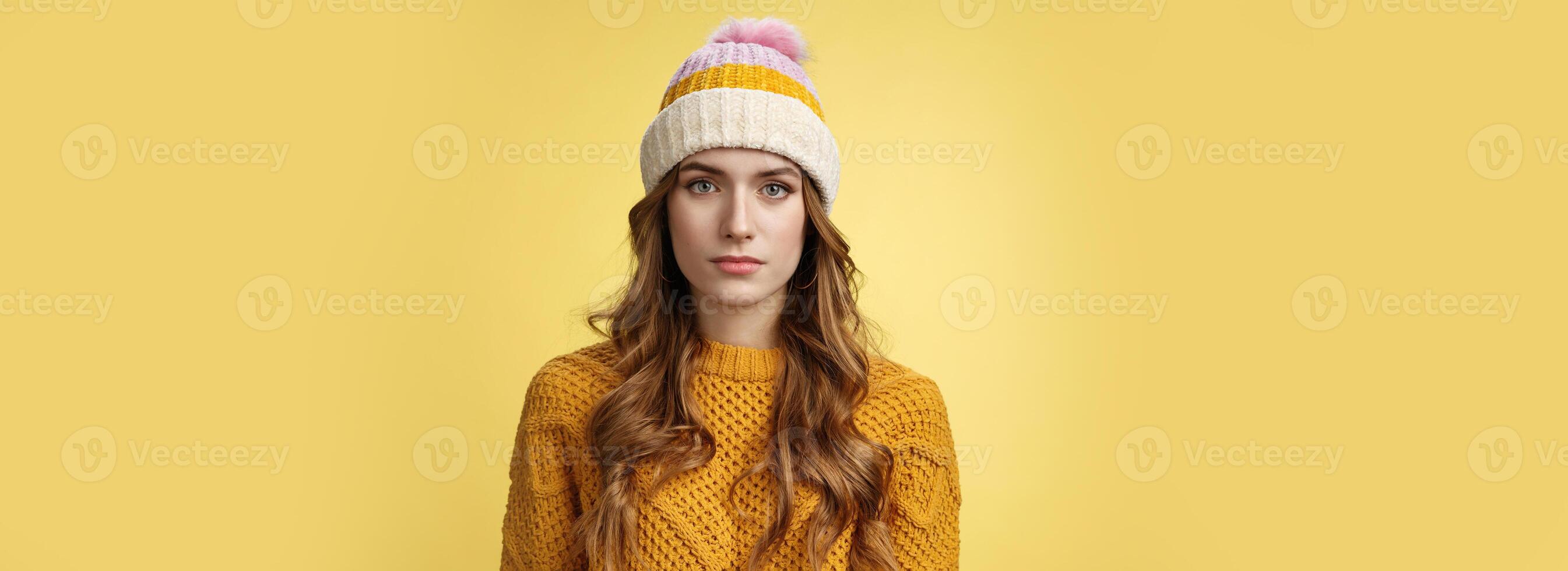 Close-up worried upset attractive young 20s woman look serious nervous sympathizing you listening terrible upsetting story standing yellow background looking camera, wearing hat sweater photo