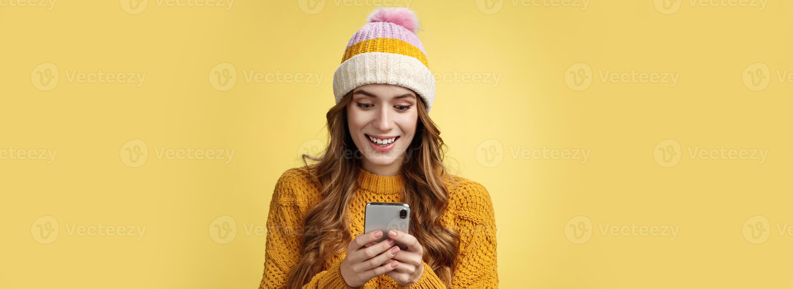 Amazed surprised cute girl receive good news reading exciting message hold smartphone widen eyes smiling mobile phone display, playing awesome cellphone game texting, send pics winters vacation photo