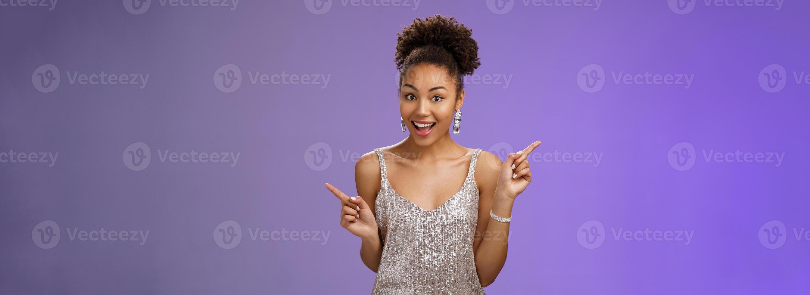 Charming outgoing african-american party girl have fun dancing pointing different sides right left show choices variants smiling broadly asking advice which way go, standing blue background photo