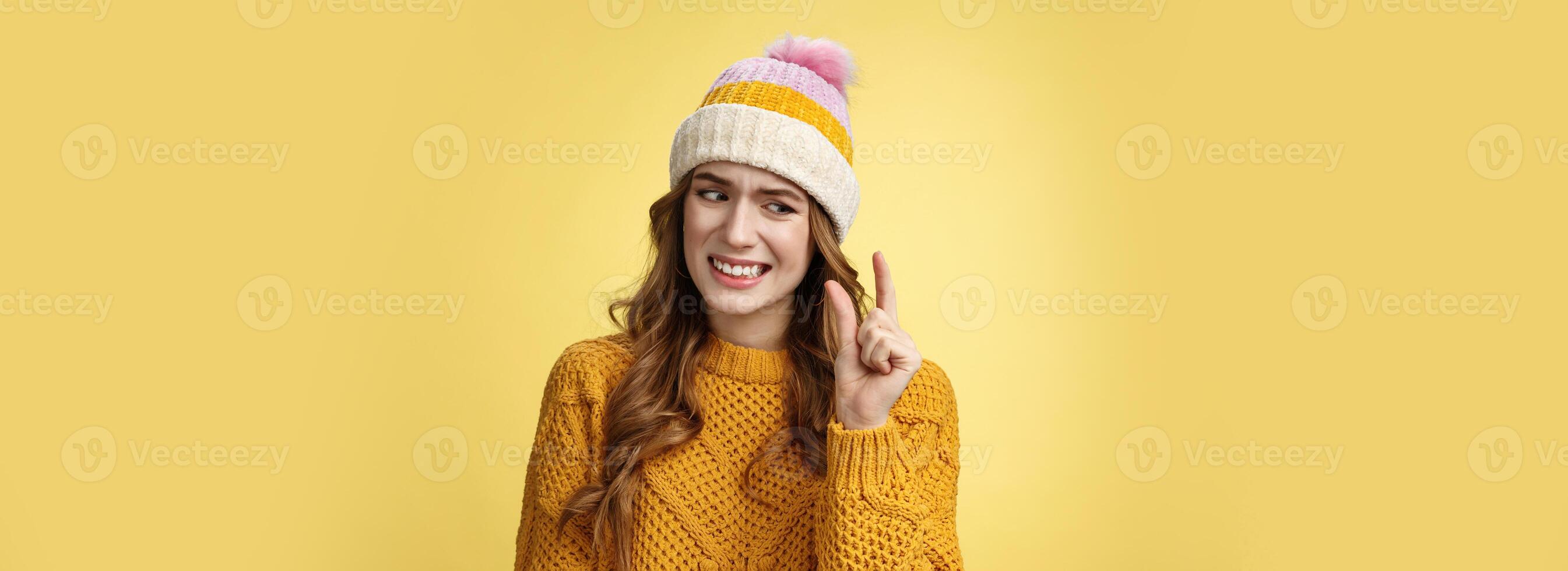 Displeased attractive picky woman describing small object show tiny thing cringing dislike disappointment look upset fingers, describing little salary new job, standing yellow background awkward photo
