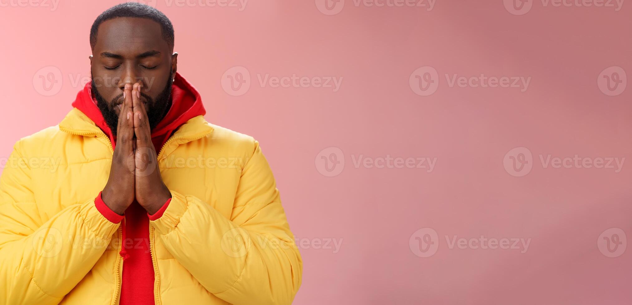 Serious-looking determined young focused african-american man prepare will important meeting press palms together hands pray close eyes supplicating praying make wish, standing pink background photo