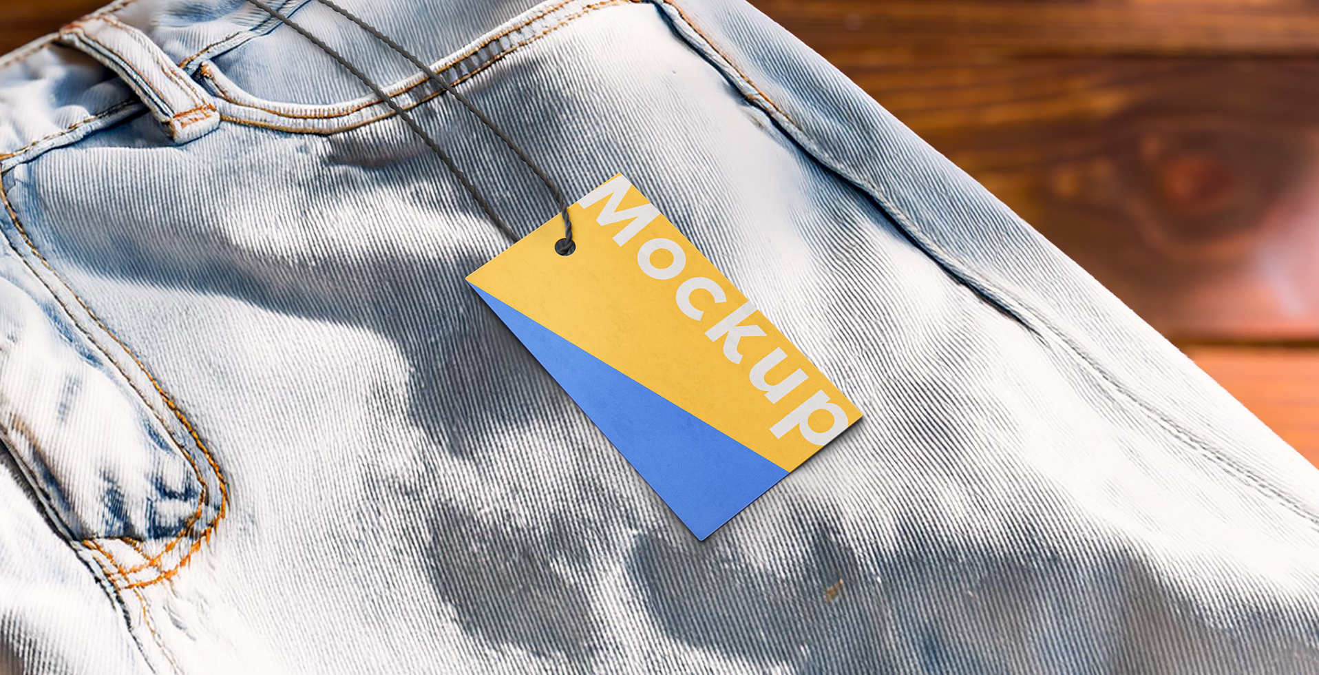 mockup of rectangular paper tag and string on jean pants with wooden background psd