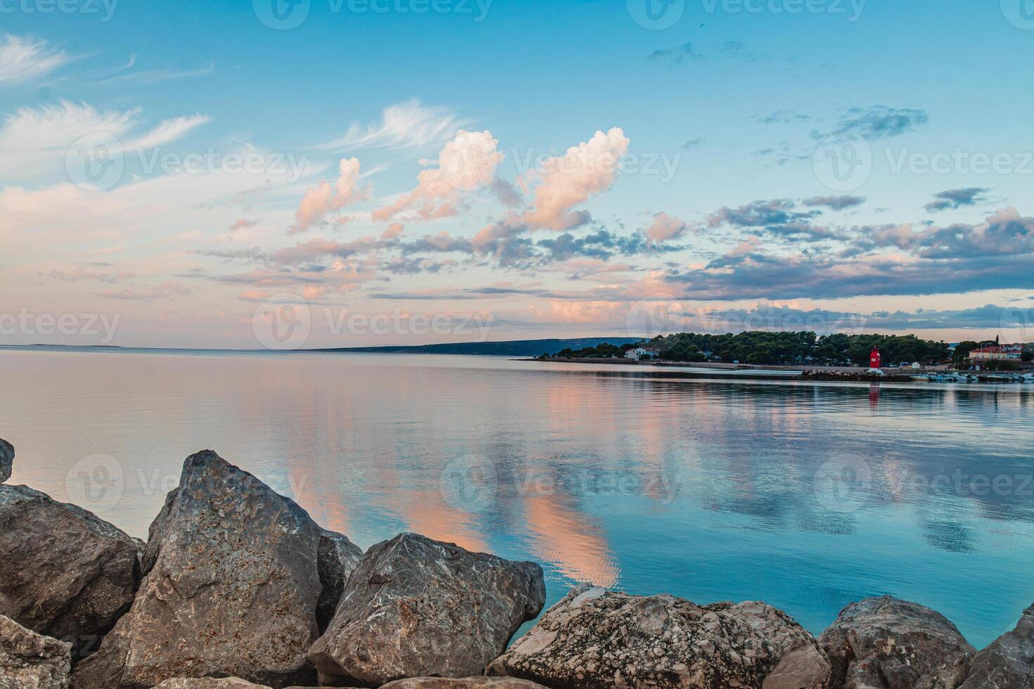 Krk Croatia 27.06.24The stone shore of the bay on the background of the old town photo