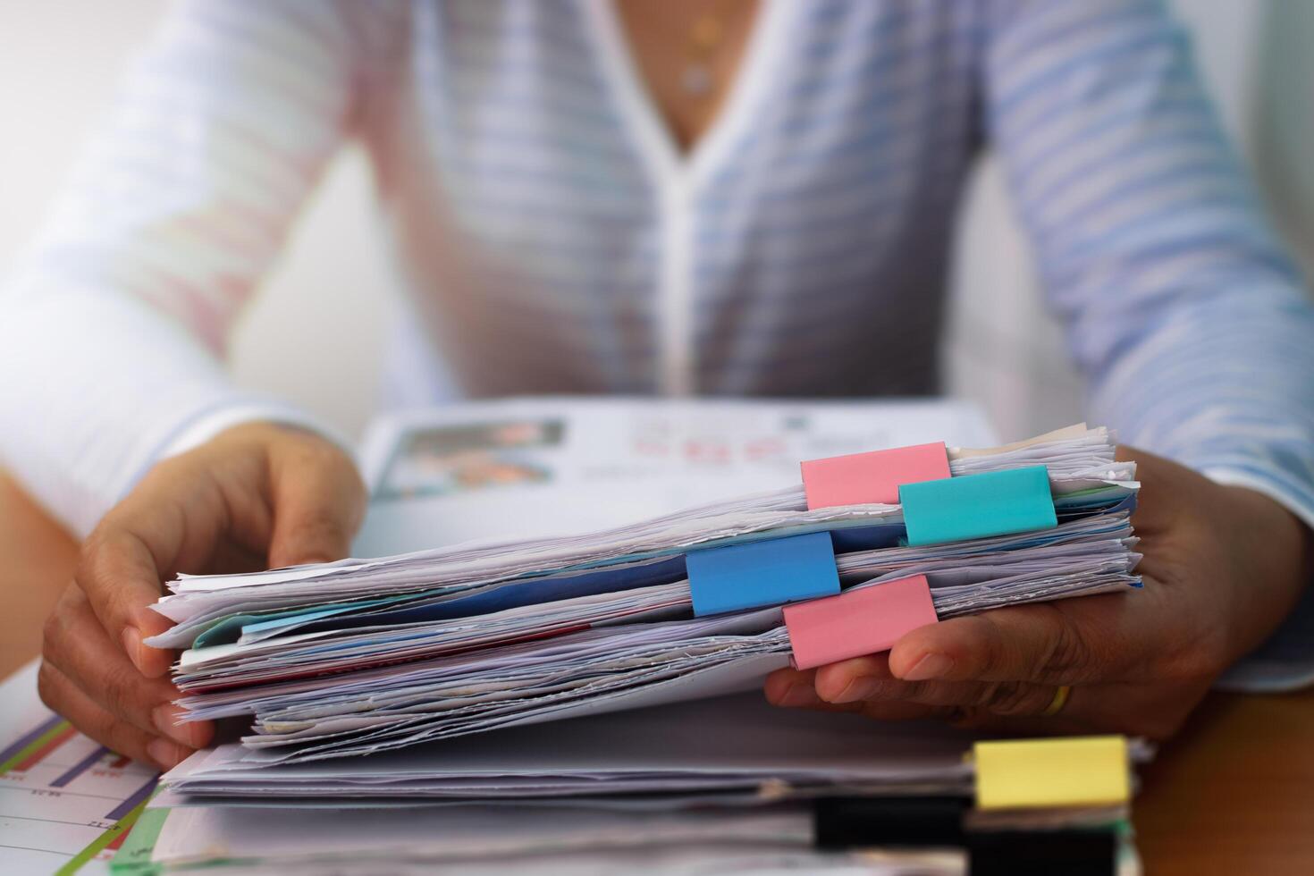 Hands of woman working with stack of paper document to calculate the cost of expenses. photo