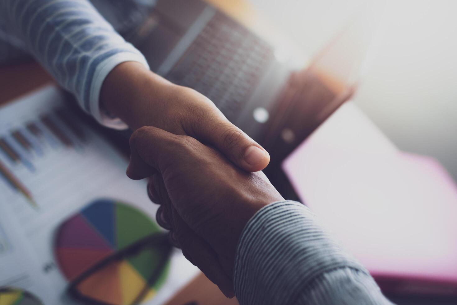 Two colleagues shaking hands together celebrating finished work. photo