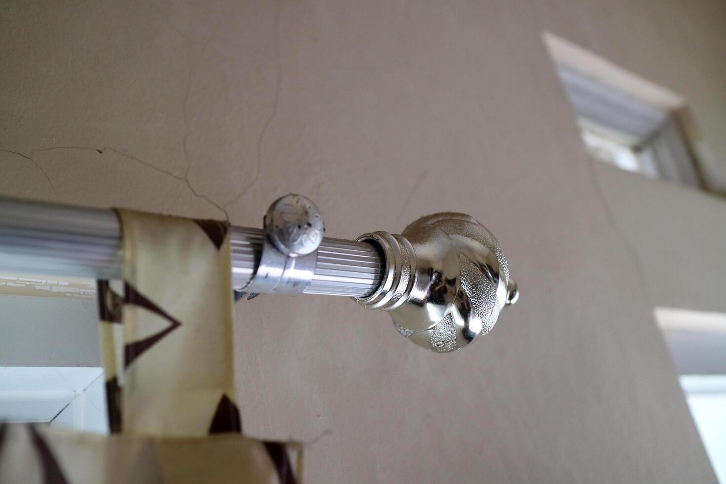 The curtain pole end cap with a round tapered shape with a chrome color, made of plastic photo