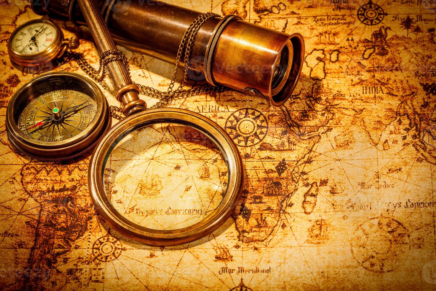 Vintage magnifying glass lies on an ancient world map photo