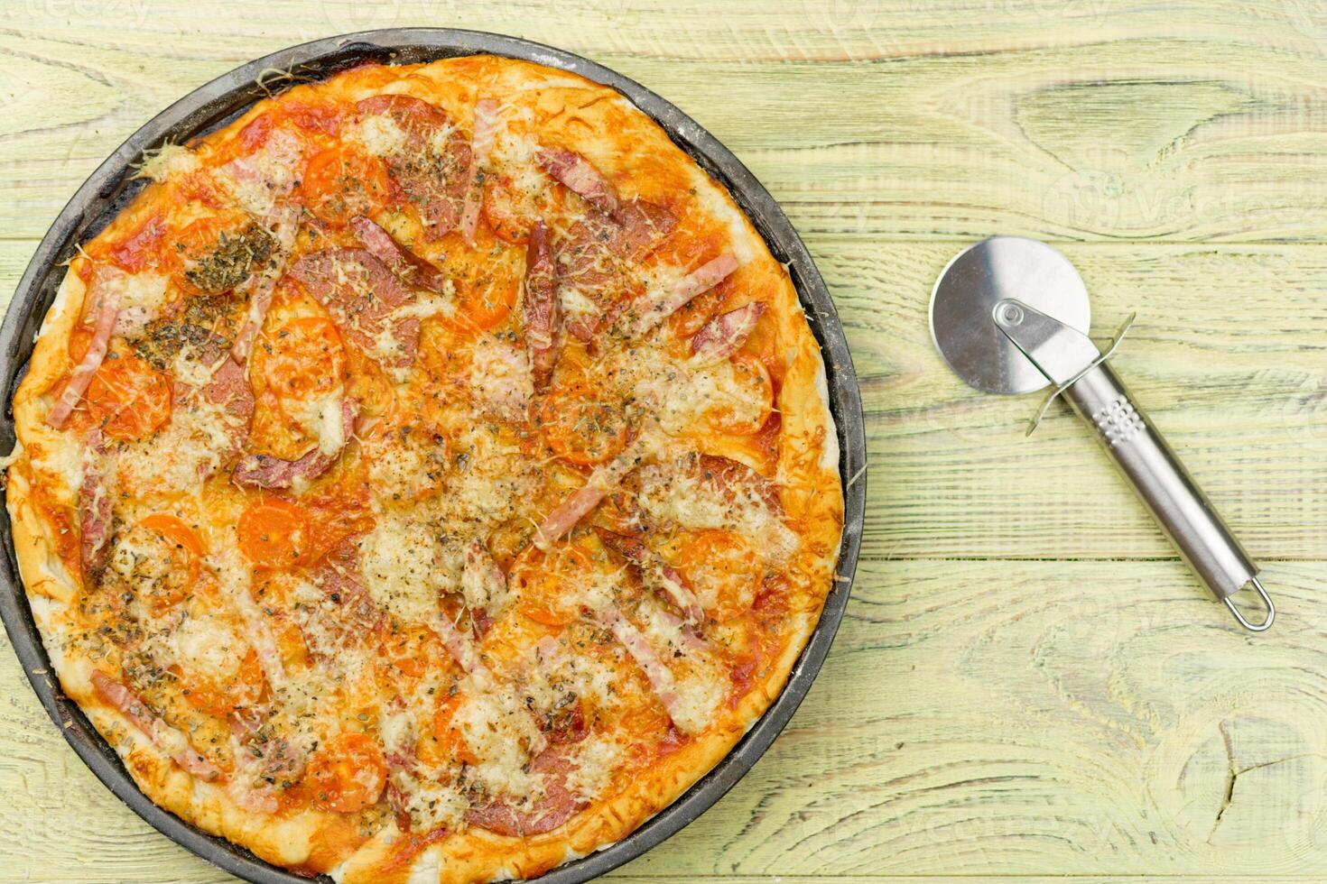 Freshly prepared homemade pizza on a baking dish. photo