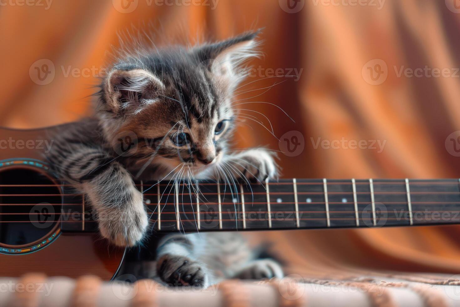 Playful Kitten Joyfully Interacting with a Guitar, Showcasing Adorable and Amusing Moments photo