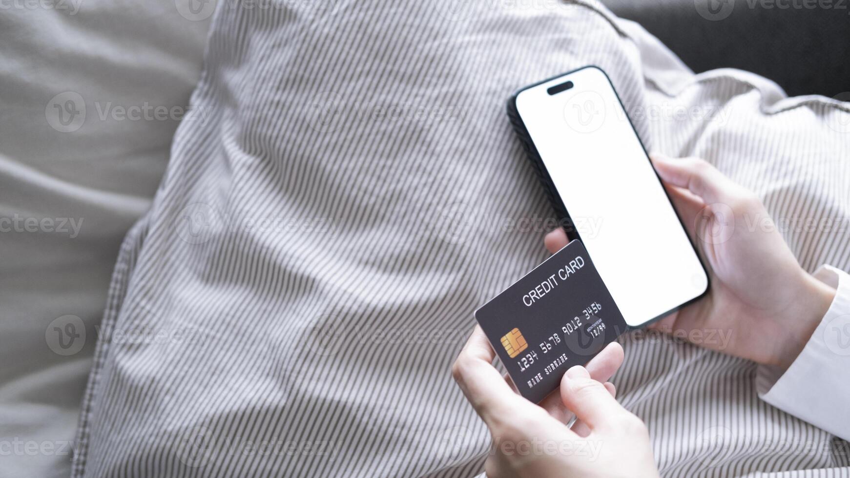 Close up female hands holding credit card and smartphone, young woman paying online, using banking service, entering information, shopping, ordering in internet store, doing secure payment photo