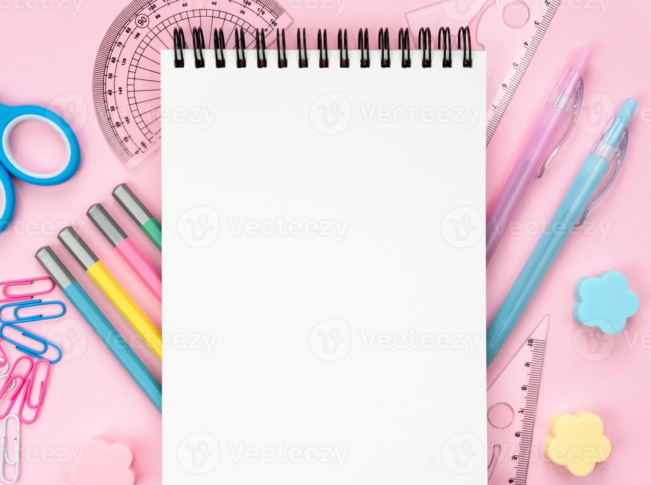 Blank notepad and school stationery on a pink background. Back to school. Mockup. Flatlay. Top view. Copy space. photo