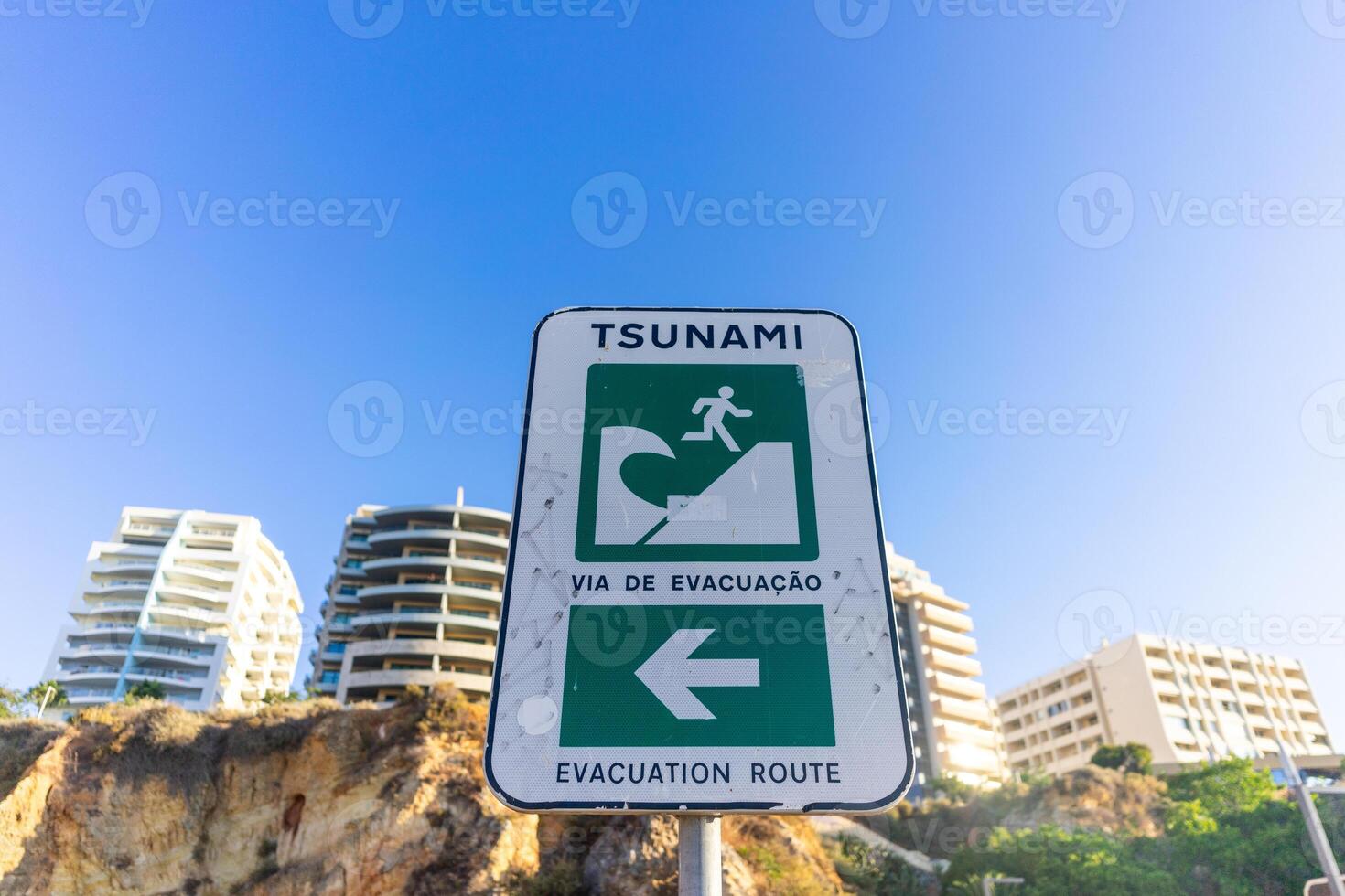 A tsunami evacuation sign at Praia da Rocha, Algarve, Portugal, guiding visitors to safety with clear instructions for emergency situations. photo