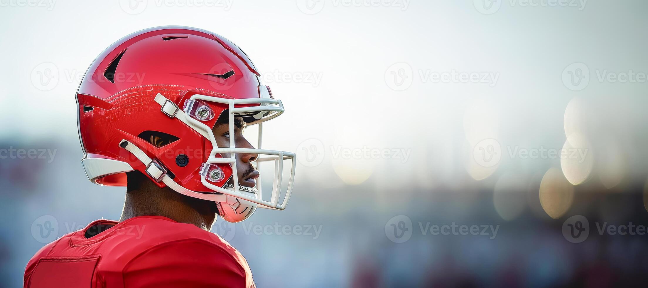 American football player in red uniform stands sideways photo