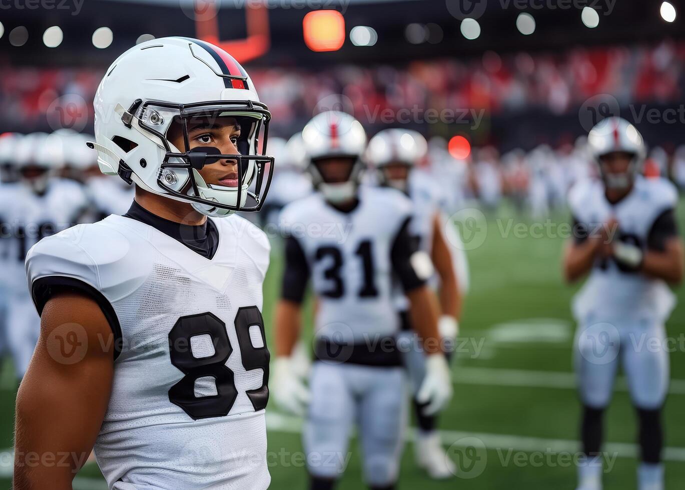 American football player in white uniform stands on the field with his team during a match photo