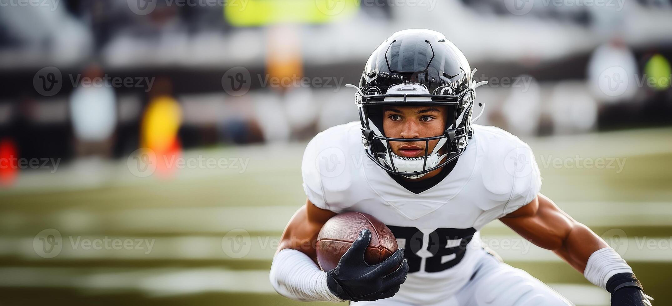 American football player in black helmet and white uniform makes a speed maneuver with ball in hand photo