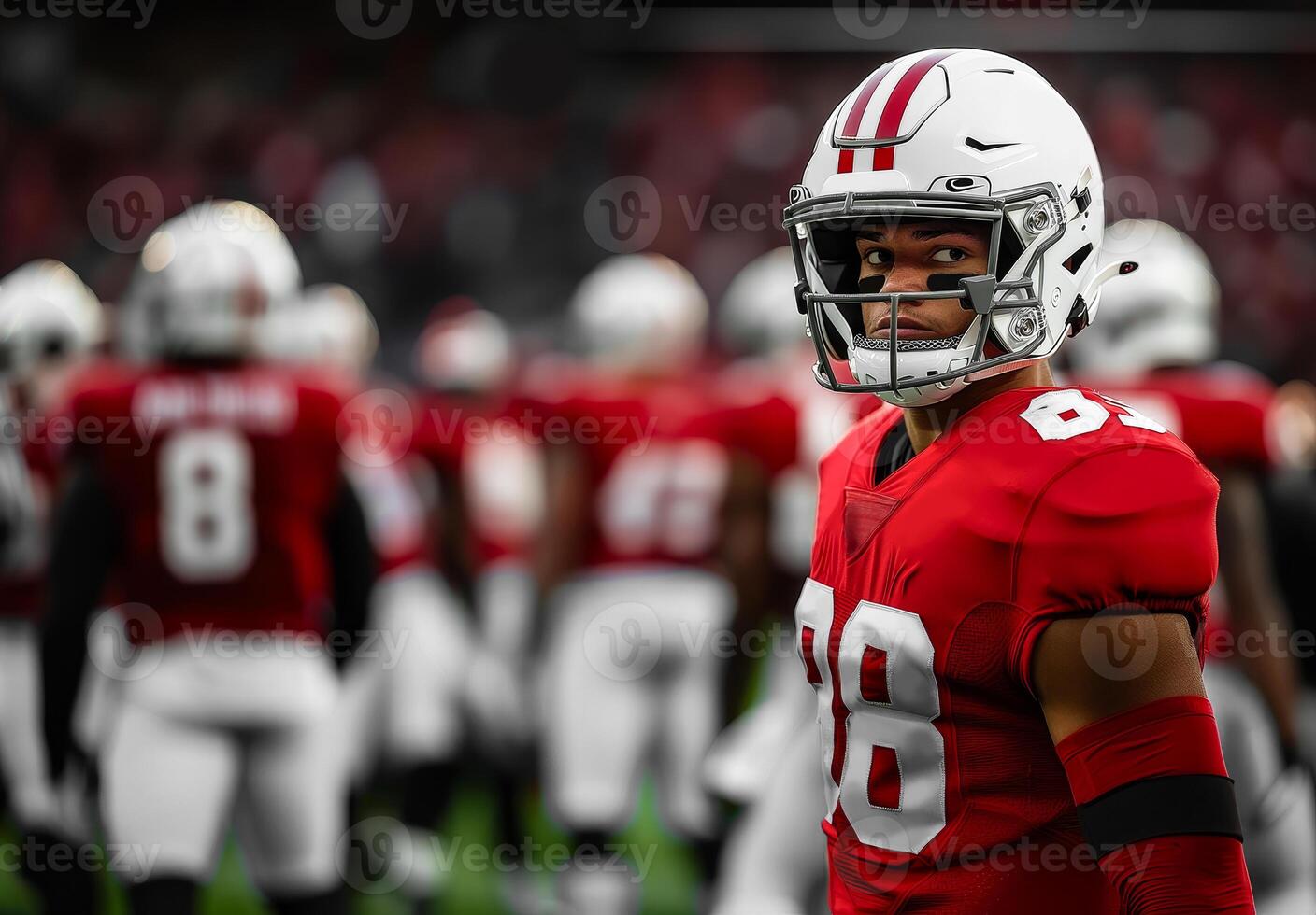 American football player in white helmet and red uniform standing and looking to the left photo