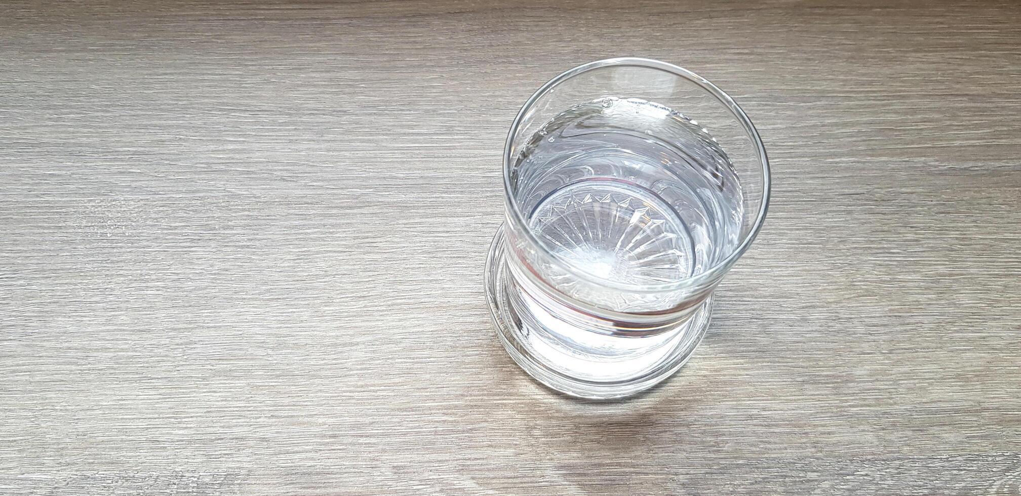 Top view of glass of water on brown wooden with copy space. Object, food and refreshment drinking on wood background concept. photo