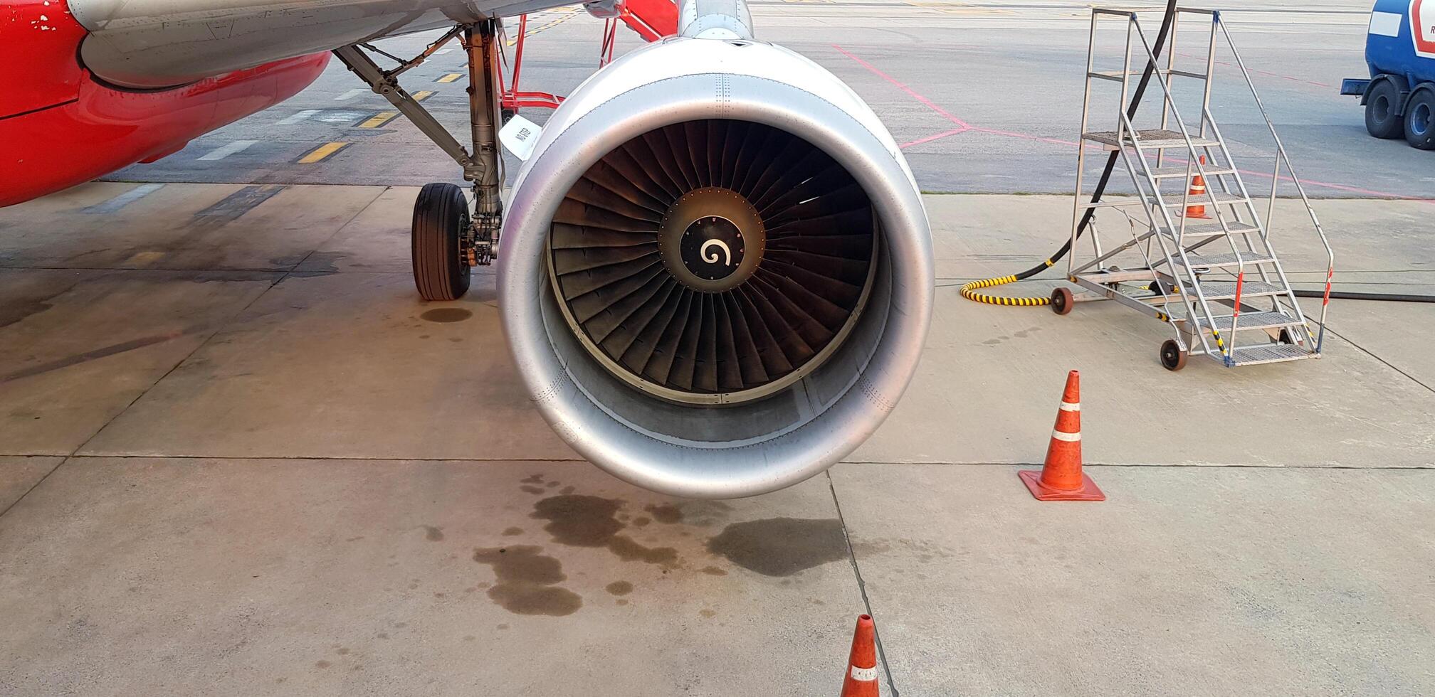 Close up jet or engine of airplane and plane parked for in maintenance area and refuel or put in gasoline on runway at Donmuang airport Bangkok, Thailand. photo