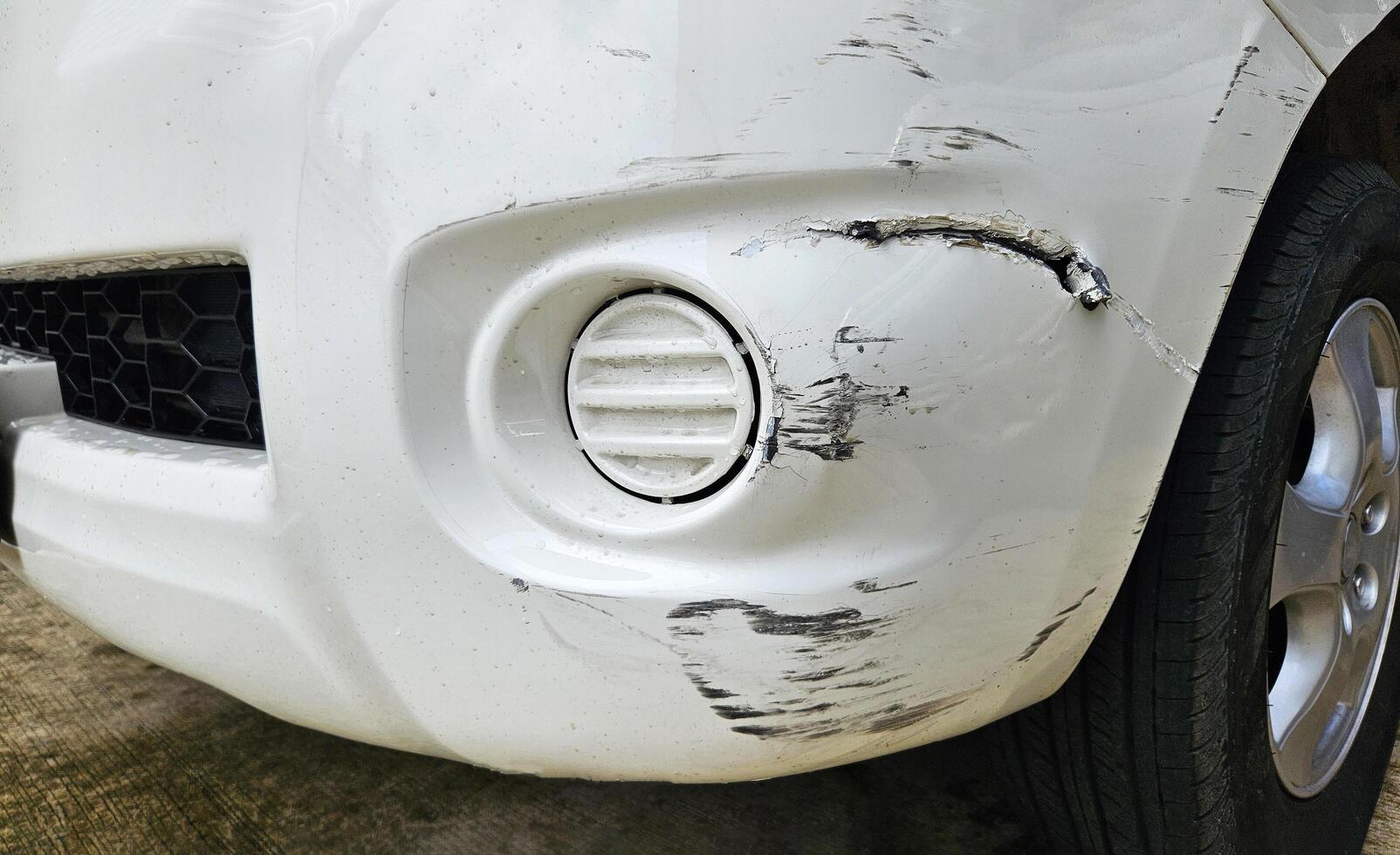Scratches on white car after accident. Damaged on front bumper with copy space. Insurance of accident or injury, Fix and maintenance concept. photo