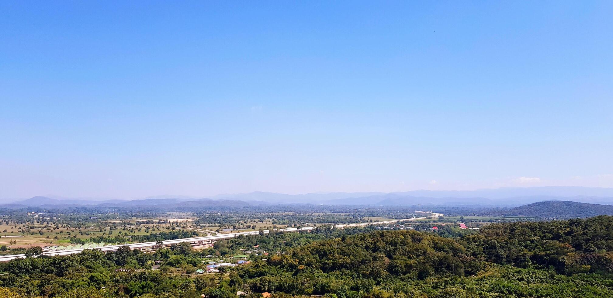 Beautiful Green forest or Jungle with mountain range, Clear blue sky, white clouds and Highway background. Beauty Landscape view and Feeling of Nature concept. photo