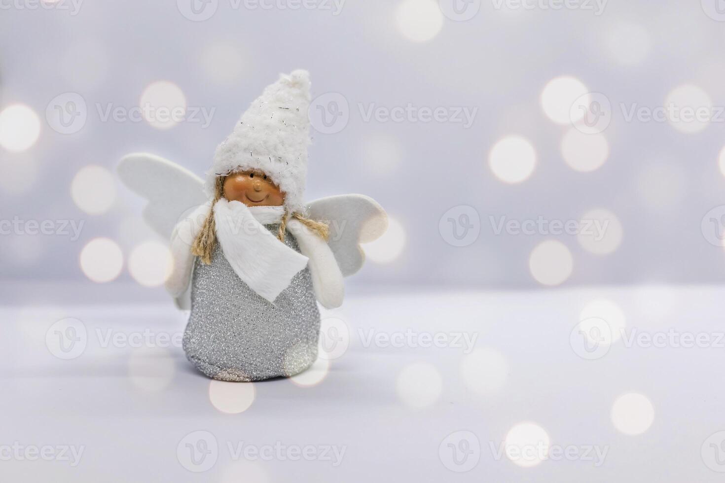 Christmas toy white angel on a white background with bokeh photo