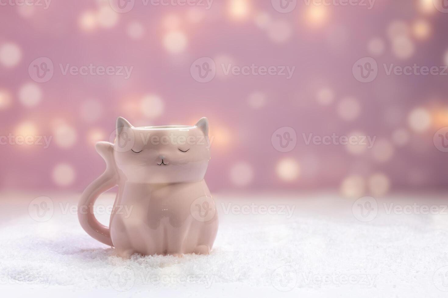pink mug in the shape of a cat on a New Year pink background with bokeh photo