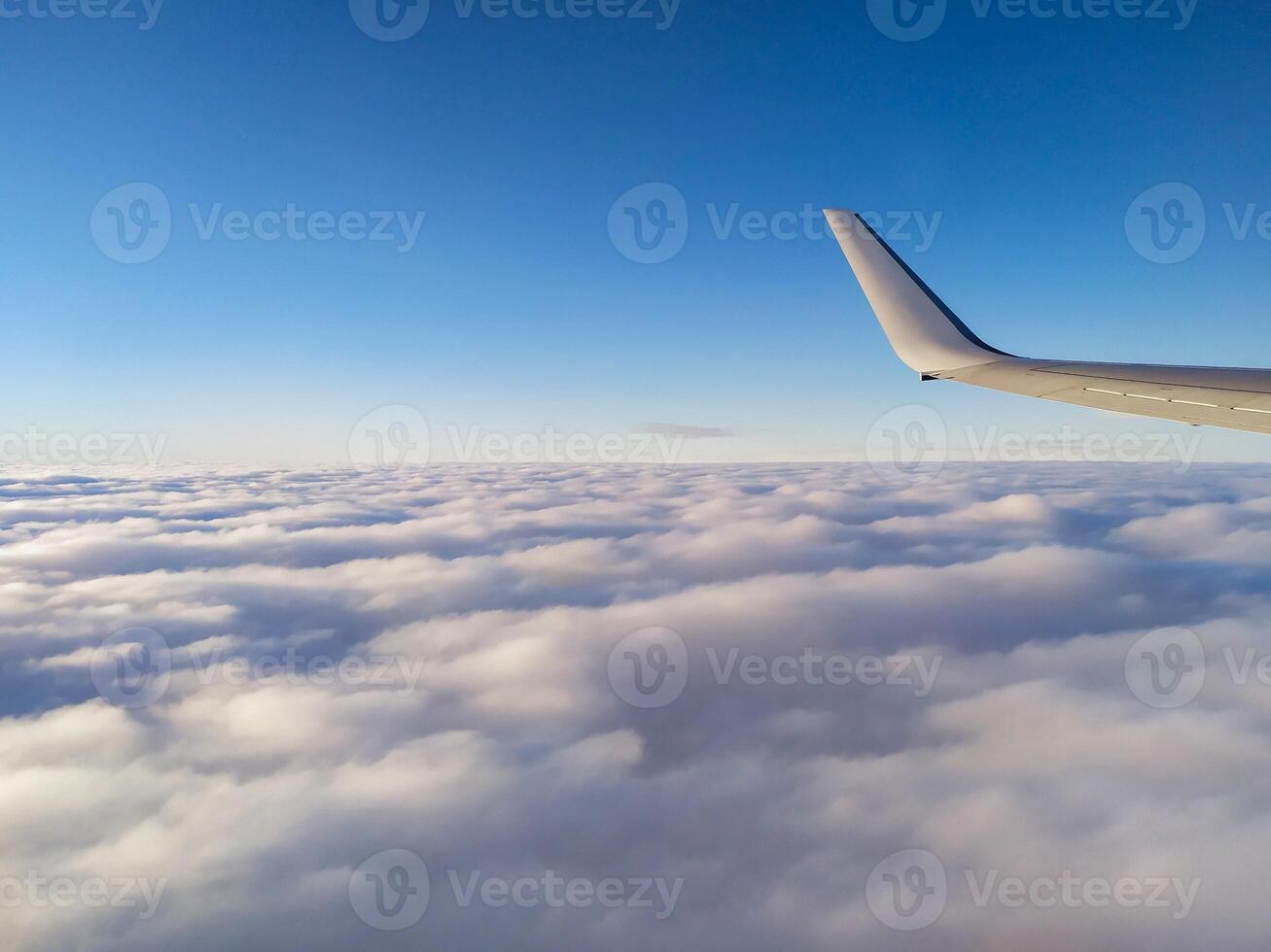 airplane tail in the clouds high in the sky photo