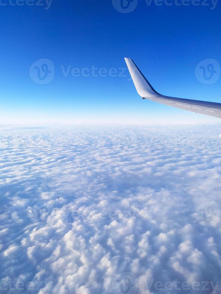 airplane tail in the clouds high in the sky photo