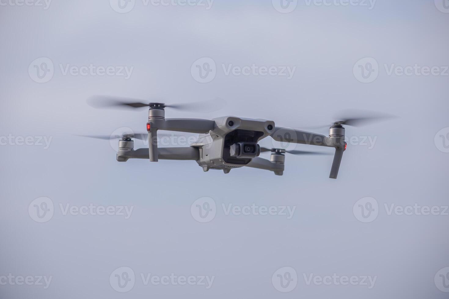 a gray drone flies in the sky photo