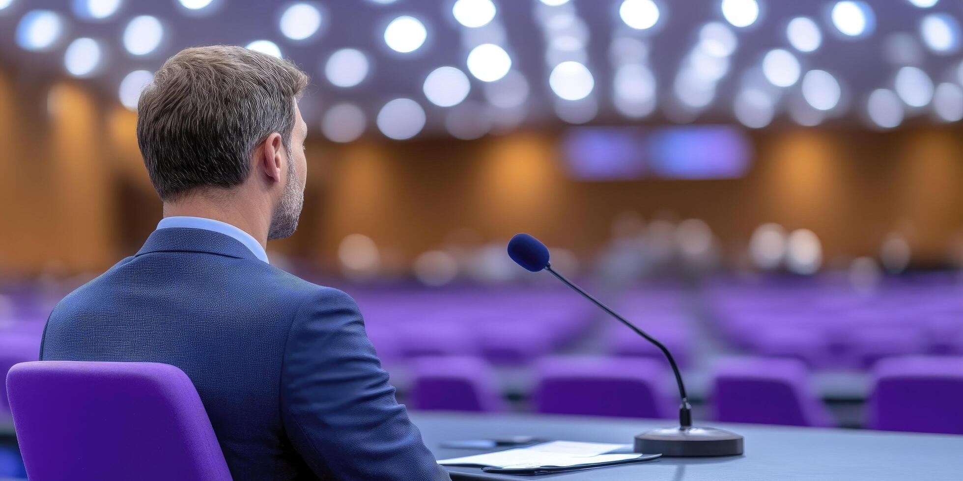 a man in suit sitting at conference room photo