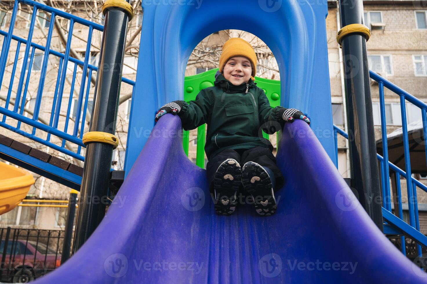 child kid boy playing on slide at playground in the park in autumn photo